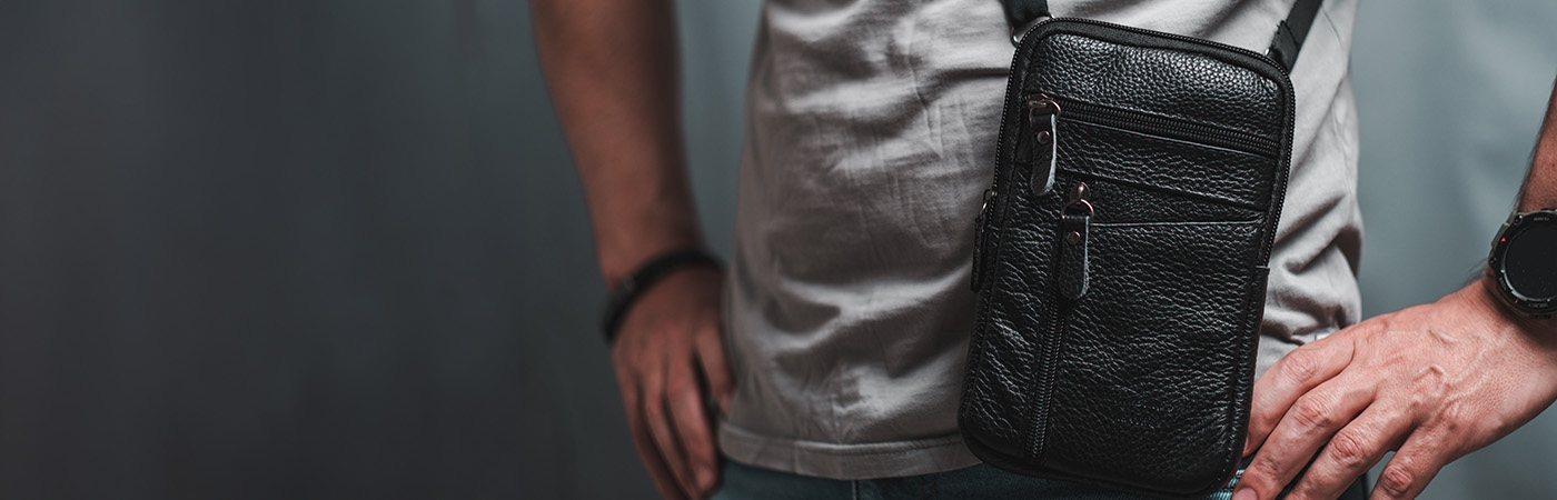 גבר עם תיק צד שחור מעור בעיצוב פרקטי ואלגנטי